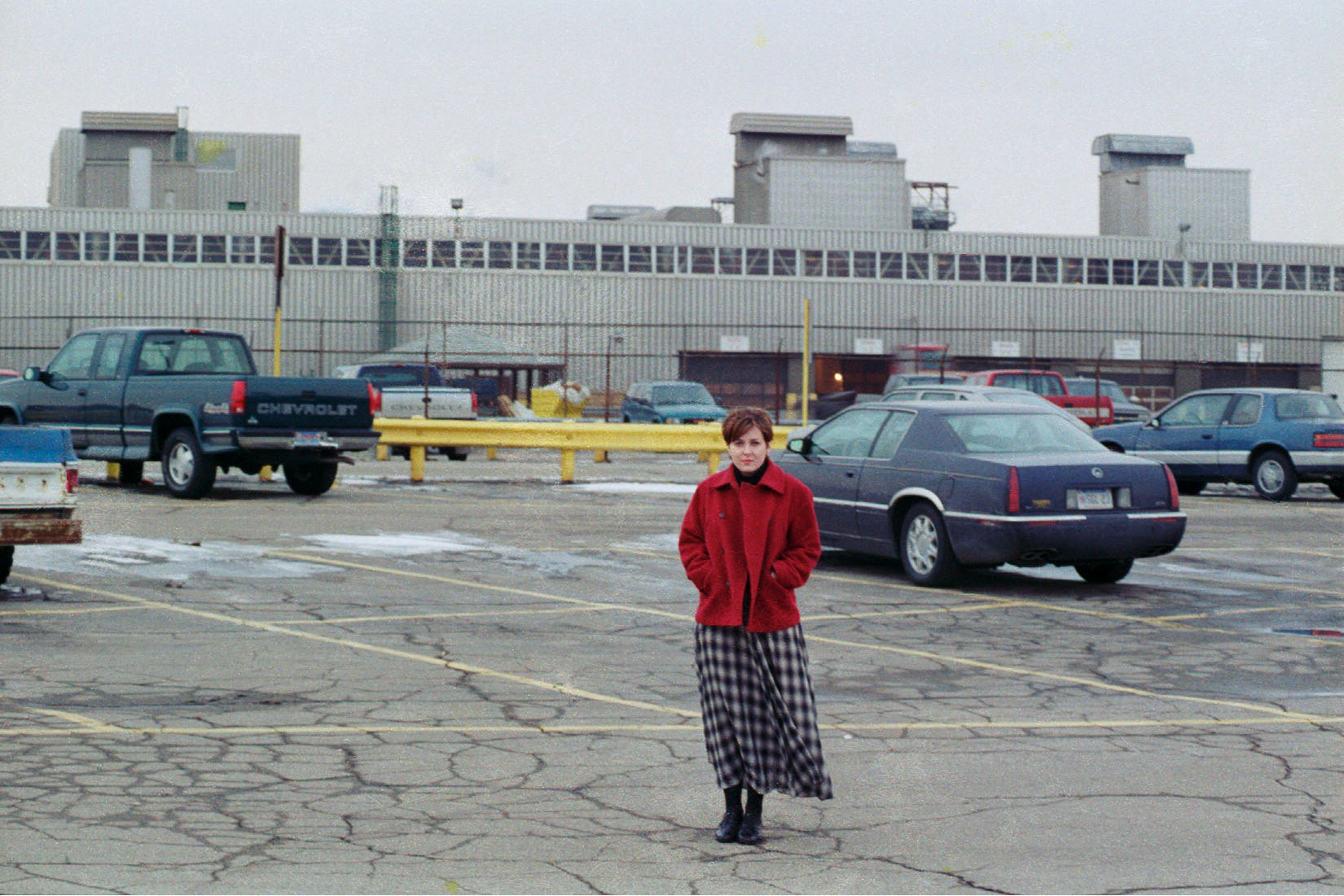 Cynthia Ivey Abitz in front of the Flint V8 Engine Plant, Bristol Rd., where her father worked for 32 years. Circa 1996, shortly before the plant was shut down and demolished.