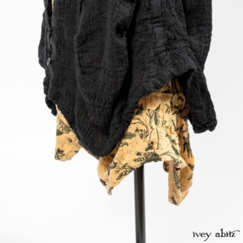 Scattergood Duster Coat in Black Crinkled Washed Linen; Scattergood Frock in Arthurian Green Floral Washed Linen. By Ivey Abitz
