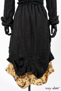 Scattergood Duster Coat in Black Crinkled Washed Linen; Scattergood Frock in Arthurian Green Floral Washed Linen. By Ivey Abitz
