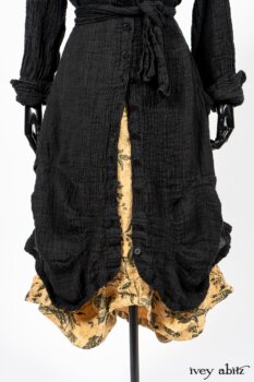 Scattergood Duster Coat in Black Crinkled Washed Linen; Scattergood Frock in Arthurian Green Floral Washed Linen. By Ivey Abitz