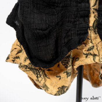 Scattergood Duster Coat in Black Crinkled Washed Linen; Scattergood Frock in Arthurian Green Floral Washed Linen. By Ivey Abitz