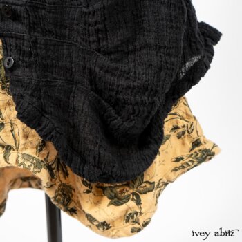 Scattergood Duster Coat in Black Crinkled Washed Linen; Scattergood Frock in Arthurian Green Floral Washed Linen. By Ivey Abitz