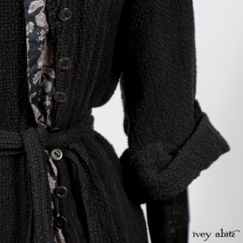 Elsie Duster Coat in Black Puckered Check Weave; Limited Edition Blanchefleur Sash in Wolfie Grey Floral Voile; Blanchefleur Frock in Black Puckered Check Weave. By Ivey Abitz