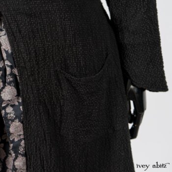 Elsie Duster Coat in Black Puckered Check Weave; Limited Edition Blanchefleur Sash in Wolfie Grey Floral Voile; Wildefield Frock in Wolfie Grey Floral Voile; Blanchefleur Frock in Black Puckered Check Weave. By Ivey Abitz