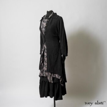 Elsie Duster Coat in Black Puckered Check Weave; Limited Edition Blanchefleur Sash in Wolfie Grey Floral Voile; Wildefield Frock in Wolfie Grey Floral Voile; Blanchefleur Frock in Black Puckered Check Weave. By Ivey Abitz