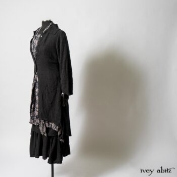 Elsie Duster Coat in Black Puckered Check Weave; Limited Edition Blanchefleur Sash in Wolfie Grey Floral Voile; Wildefield Frock in Wolfie Grey Floral Voile; Blanchefleur Frock in Black Puckered Check Weave. By Ivey Abitz