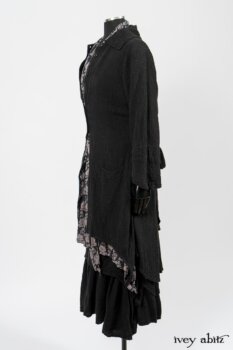 Elsie Duster Coat in Black Puckered Check Weave; Limited Edition Blanchefleur Sash in Wolfie Grey Floral Voile; Wildefield Frock in Wolfie Grey Floral Voile; Blanchefleur Frock in Black Puckered Check Weave. By Ivey Abitz