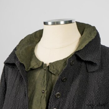 Elsie Duster Coat in Black Puckered Check Weave; Limited Edition Arthur Hill Shirt in Arthurian Green Cotton Voile; Blanchefleur Trousers in Black and Natural Plaid Weave. By Ivey Abitz
