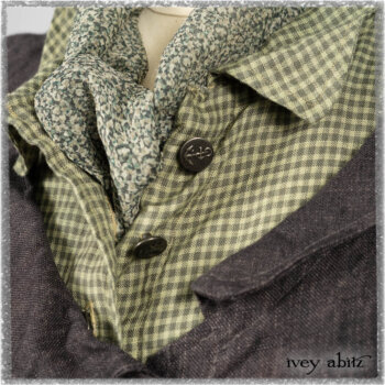 Chevallier Duster Coat in Anchor Grey Wondrous Washed Linen; Chevallier Shirt in Seagrass Petite Check Linen; Chevallier Trousers in Seagrass Herringbone Twill with contrasting lacing to match shirt; Clotaire Sash in Pointillism Silk Chiffon. Ivey Abitz bespoke clothing.