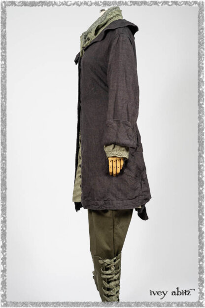 Chevallier Duster Coat in Anchor Grey Wondrous Washed Linen; Chevallier Shirt in Seagrass Petite Check Linen; Chevallier Trousers in Seagrass Herringbone Twill with contrasting lacing to match shirt; Clotaire Sash in Pointillism Silk Chiffon. Ivey Abitz bespoke clothing.