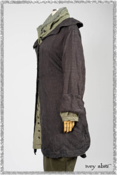 Chevallier Duster Coat in Anchor Grey Wondrous Washed Linen; Chevallier Shirt in Seagrass Petite Check Linen; Chevallier Trousers in Seagrass Herringbone Twill with contrasting lacing to match shirt; Clotaire Sash in Pointillism Silk Chiffon. Ivey Abitz bespoke clothing.
