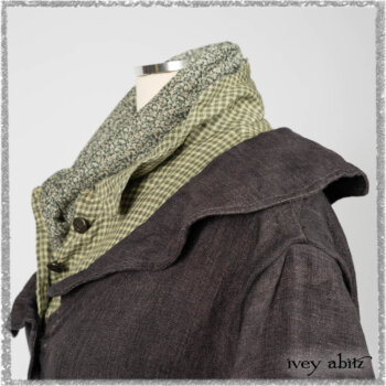 Chevallier Duster Coat in Anchor Grey Wondrous Washed Linen; Chevallier Shirt in Seagrass Petite Check Linen; Chevallier Trousers in Seagrass Herringbone Twill with contrasting lacing to match shirt; Clotaire Sash in Pointillism Silk Chiffon. Ivey Abitz bespoke clothing.