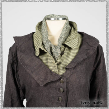 Chevallier Duster Coat in Anchor Grey Wondrous Washed Linen; Chevallier Shirt in Seagrass Petite Check Linen; Chevallier Trousers in Seagrass Herringbone Twill with contrasting lacing to match shirt; Clotaire Sash in Pointillism Silk Chiffon. Ivey Abitz bespoke clothing.