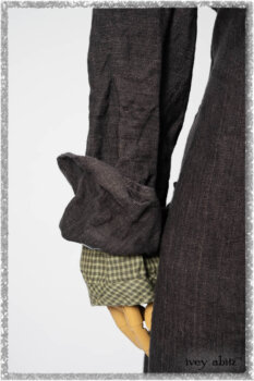 Chevallier Duster Coat in Anchor Grey Wondrous Washed Linen; Chevallier Shirt in Seagrass Petite Check Linen; Chevallier Trousers in Seagrass Herringbone Twill with contrasting lacing to match shirt; Clotaire Sash in Pointillism Silk Chiffon. Ivey Abitz bespoke clothing.