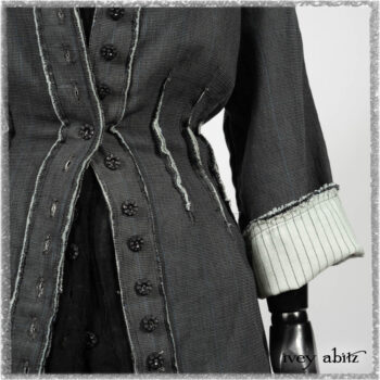 Trelawny Duster Coat in Estuary and Black Houndstooth on Pinstripe; Trelawny Vest in Beacon Black Hemstitch Stripe Gauze; Clotaire Sash in Ethereal Cream and Black Fleur Stretch Cotton; Ardsleydale Frock in Ethereal Cream Embroidered Crushed Plaid. Ivey Abitz bespoke clothing.