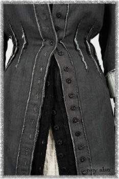Trelawny Duster Coat in Estuary and Black Houndstooth on Pinstripe; Trelawny Vest in Beacon Black Hemstitch Stripe Gauze; Clotaire Sash in Ethereal Cream and Black Fleur Stretch Cotton; Ardsleydale Frock in Ethereal Cream Embroidered Crushed Plaid. Ivey Abitz bespoke clothing.