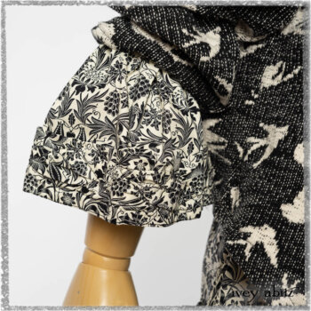 Elliot Jacket in Beacon Black Flora and Fauna Knit; Tollie Dress in Estuary Cream and Black Fleur Stretch Cotton; Clotaire Sash in Ethereal Cream and Black Fleur Stretch Cotton; Mewland Skirt in Black Washed Crinkled Linen. Ivey Abitz bespoke clothing.