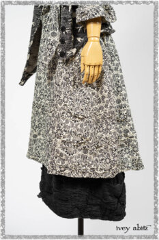 Elliot Jacket in Beacon Black Flora and Fauna Knit; Tollie Dress in Estuary Cream and Black Fleur Stretch Cotton; Clotaire Sash in Ethereal Cream and Black Fleur Stretch Cotton; Mewland Skirt in Black Washed Crinkled Linen. Ivey Abitz bespoke clothing.