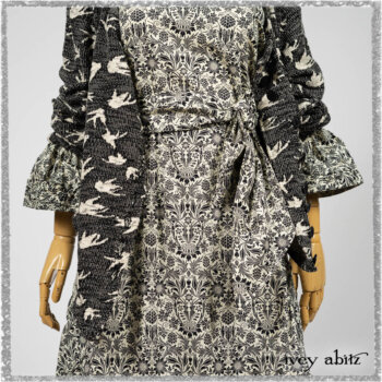 Elliot Jacket in Beacon Black Flora and Fauna Knit; Tollie Dress in Estuary Cream and Black Fleur Stretch Cotton; Clotaire Sash in Ethereal Cream and Black Fleur Stretch Cotton; Mewland Skirt in Black Washed Crinkled Linen. Ivey Abitz bespoke clothing.