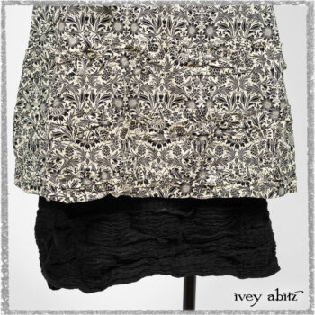 Elliot Jacket in Beacon Black Flora and Fauna Knit; Tollie Dress in Estuary Cream and Black Fleur Stretch Cotton; Clotaire Sash in Ethereal Cream and Black Fleur Stretch Cotton; Mewland Skirt in Black Washed Crinkled Linen. Ivey Abitz bespoke clothing.