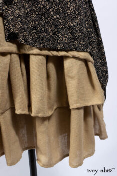 Baudelaire Duster Coat in Mansard Roof and Sandstone Washed Crepe; Delphine Dress in Mansard Roof and Sandstone Sprig Silk Chiffon; Lydia Neck Wrap and Lydia Arm Sleeves in Signature Black Washed Knit; Everett Frock in Sandstone Washed Weave.