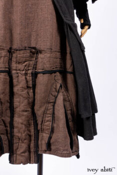 Everett Duster Coat in Mansard Roof Coat Weave; Lydia Neck Wrap and Lydia Arm Wraps in Signature Black Washed Knit; Roebling Frock in Brownstone Washed Linen; Cilla Slip Frock in Signature Black Washed Knit.