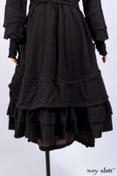 Everett Duster Coat in Mansard Roof Coat Weave; Lydia Neck Wrap and Lydia Arm Wraps in Signature Black Washed Knit; Roebling Frock in Brownstone Washed Linen; Cilla Slip Frock in Signature Black Washed Knit.