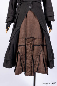 Everett Duster Coat in Mansard Roof Coat Weave; Lydia Neck Wrap and Lydia Arm Wraps in Signature Black Washed Knit; Roebling Frock in Brownstone Washed Linen; Cilla Slip Frock in Signature Black Washed Knit.