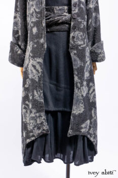 Monceau Duster Coat in Mansard Roof Washed Floral Woolen Weave; Lydia Neck Wrap in Slate Washed Linen; Blanchefleur Dress in Mansard Roof Washed Weave; Cilla Slip Frock in Signature Black Ribbed Knit; Porte Cochere Sash in Mansard Roof Washed Floral Woolen Weave.