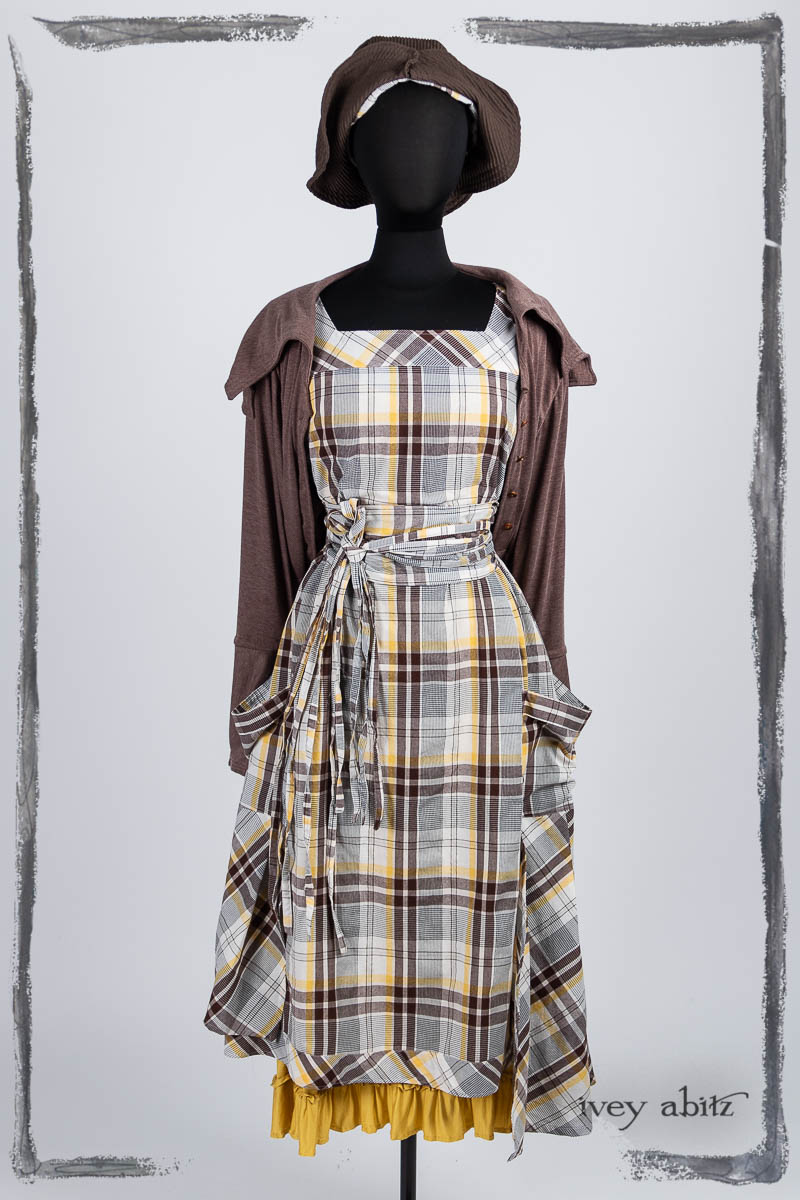 Meriwether Frock in Clapboard Cottage Washed Plaid; Furtherafield Jacket in Clapboard Cottage Softest Knit; Porte Cochere Sash in Clapboard Cottage Washed Plaid; Essentielle Frock in Marigold Plant Based Knit; Hapgood Hat in Clapboard Cottage Ribbed Weave. Bespoke clothing by Ivey Abitz.