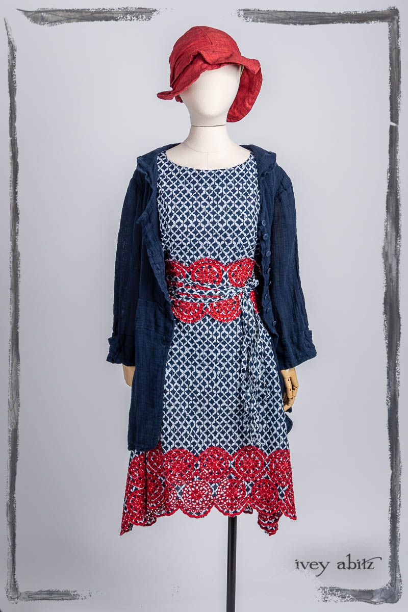 Pique-nique Frock in Bastille Blue and Poppy Embroidered Weave; Pique-nique Sash in Bastille Blue and Poppy Embroidered Weave; Campanella Shirt Jacket in Bastille Blue Washed Crinkled Weave; Hapgood Hat in Poppy Washed Linen. Bespoke clothing by Ivey Abitz.