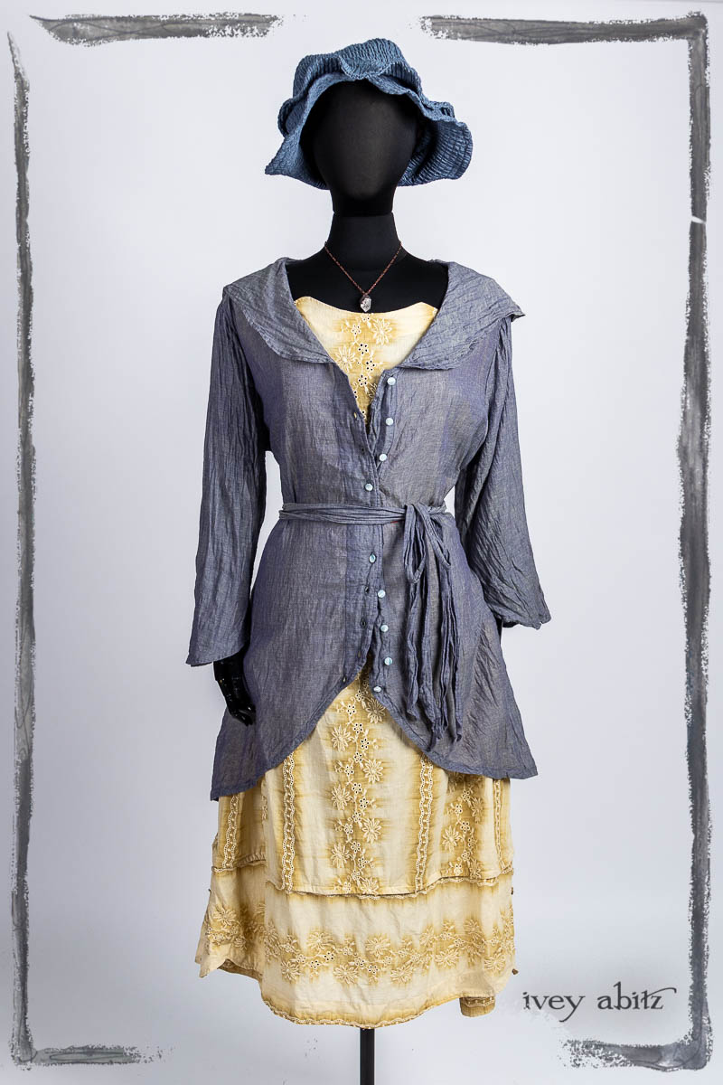 Arthur Hill Duster Coat in Bluebell Cross Woven Washed Voile; Harrison Frock in High Tea Embroidered Voile; Hapgood Hat in Bluebell Puckered Hat Weave; Nouvelle Necklace. Bespoke clothing by Ivey Abitz.