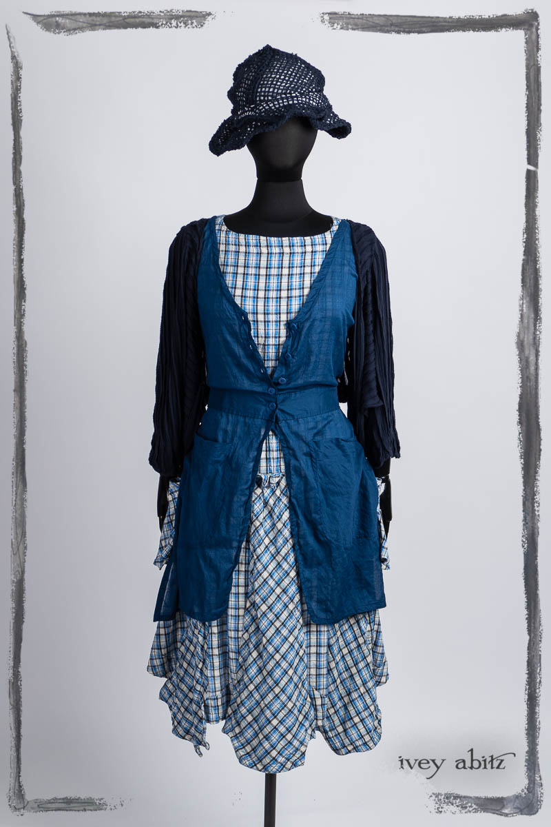 Campanella Shirt Jacket in Bastille Blue Washed Crinkled Weave; Campanella Overlay in Seaside Washed Batiste; Furthafield Frock in Seaside Woven Plaid; Hapgood Hat in Bastille Blue Open Weave Knit; Bespoke clothing by Ivey Abitz.