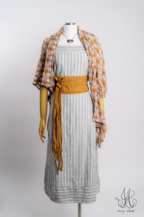 Rosemarie Wrap in Ripe Apricot Embroidered Weave; Porte Cochere Sash in Ripe Apricot Washed Weave; Merrily Frock in Raindrop Stripe Washed Weave; Heirloom Necklace.