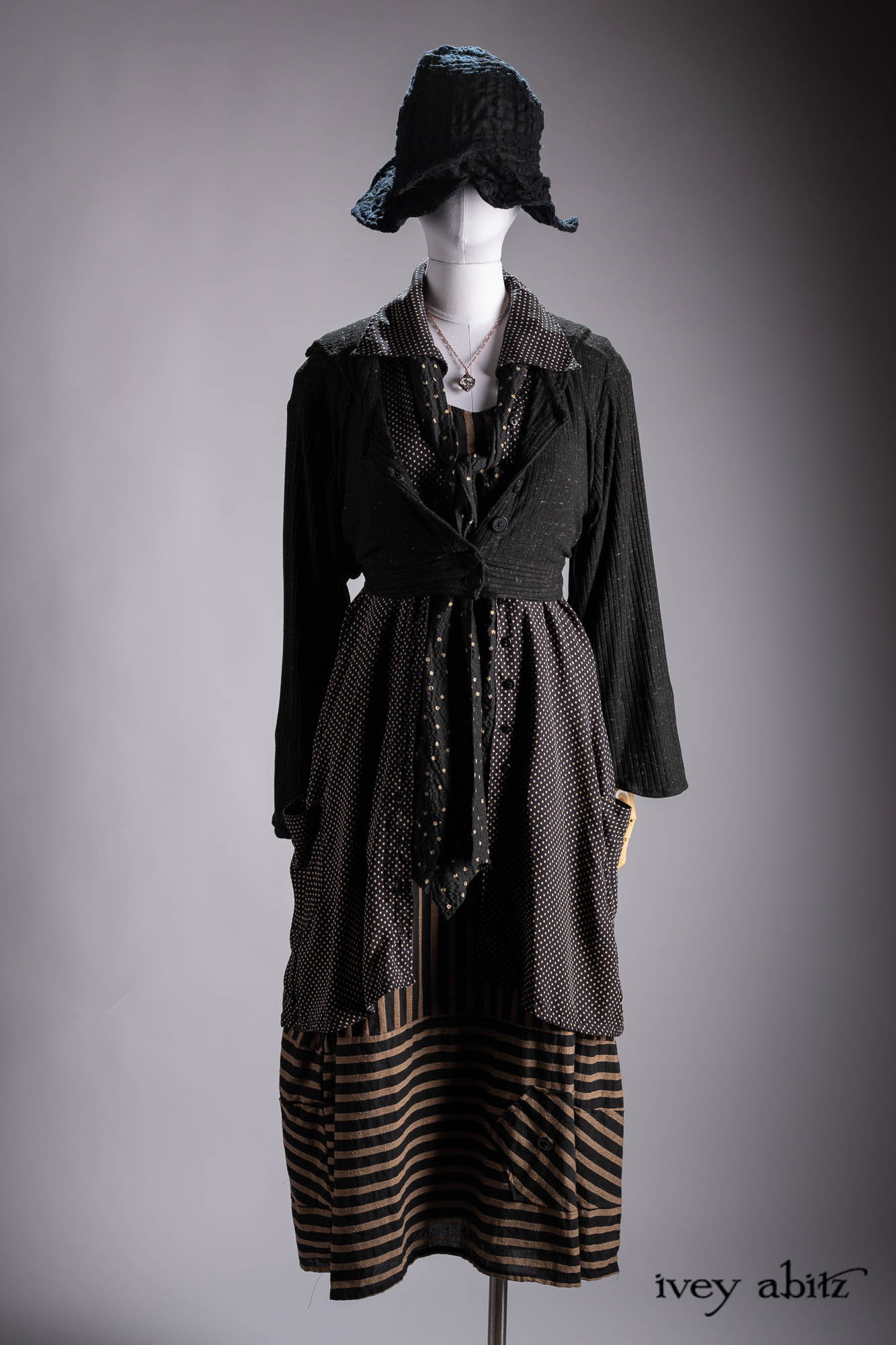 Ellis Duster Coat in Idyllic Green Woven Weave; Pierrepont Shirt in Crimson Three-Leaf Silk; Liberte Frock in Riverbank Floral Woven Weave; Cilla Slip Frock in Bark Silky Knit; Hapgood Hat in Bark Washed Woven Hat Weave; Nouvelle Necklace.