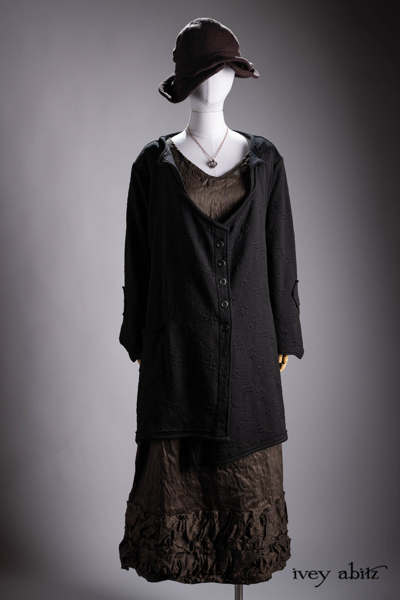 Ellis Duster Coat in Idyllic Green Woven Weave; Pierrepont Shirt in Crimson Three-Leaf Silk; Liberte Frock in Riverbank Floral Woven Weave; Cilla Slip Frock in Bark Silky Knit; Hapgood Hat in Bark Washed Woven Hat Weave; Nouvelle Necklace.