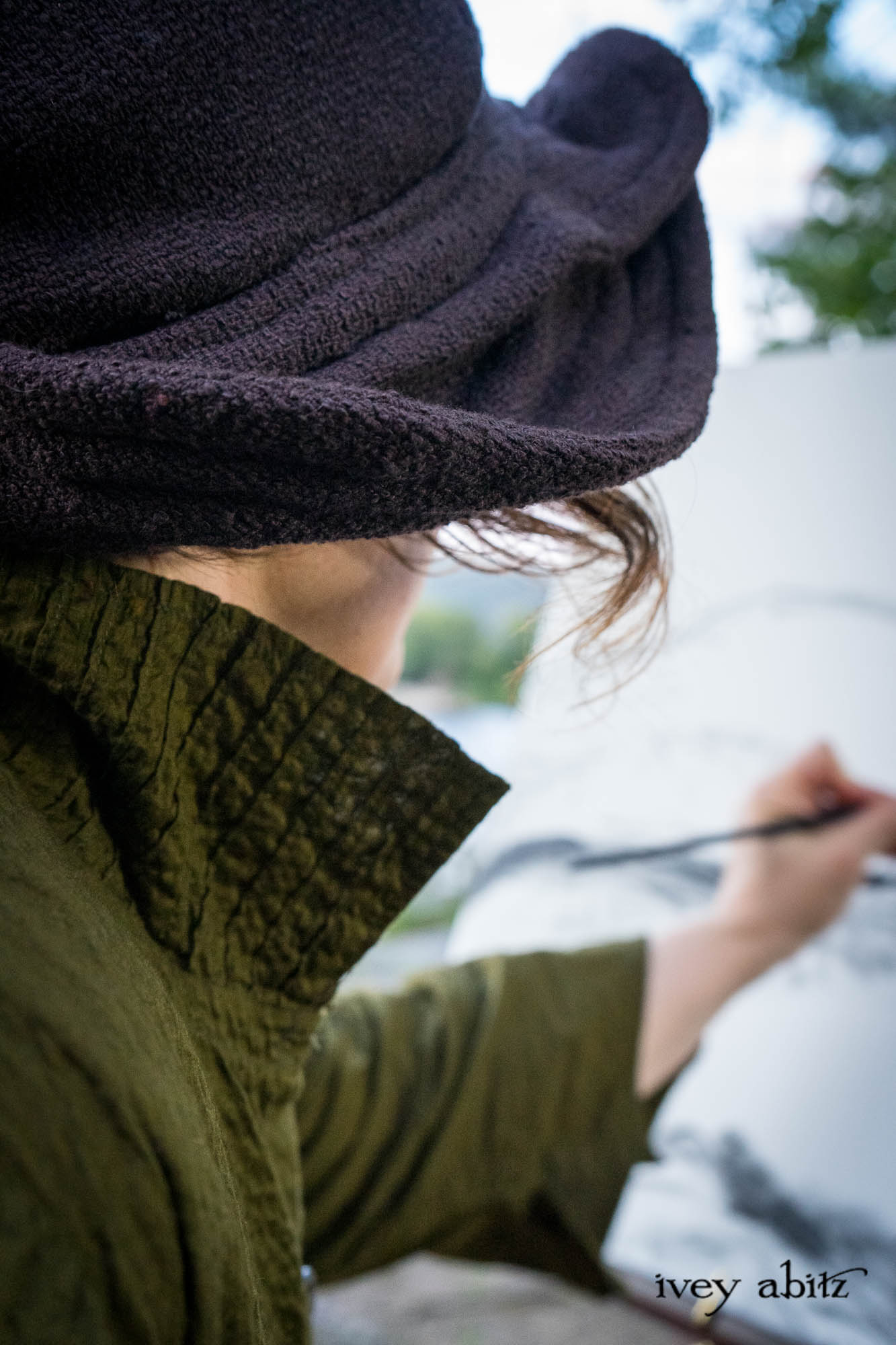 Cynthia Ivey Abitz painting Anthony's Nose and Hessian Lake on location. Ellis Duster Coat in Idyllic Green Woven Weave Baedeker Scarf in Bark Mottled Mohair Hat and Scarf Knit Hapgood Hat in Bark Washed Woven Hat Weave Ellis Shirt in Idyllic Green Puckered Voile Liberté Frock in Riverbank Floral Woven Weave Cilla Slip Frock in Bark Silky Knit Heirloom Necklace