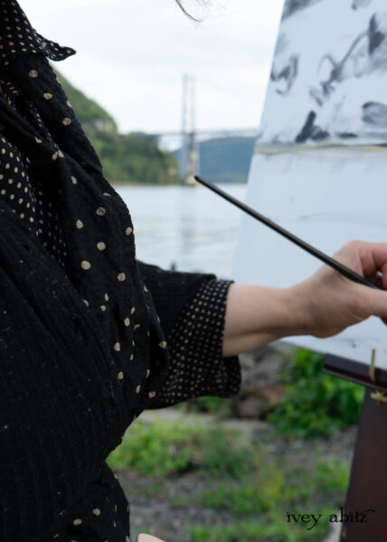 Painting Anthony's Nose and the Bear Mountain Bridge at the banks of the Hudson River. Eugenia Jacket in Mountain Mottled Ribbed Knit Baedeker Shirt Jacket in Mountain and Riverbank Petite Dot Silk Harbourhill Tie in Mountain and Riverbank Puckered Dot Cotton Baedeker Frock in Mountain and Riverbank Stripe Silk Hapgood Hat in Black Plaid Hat Weave Nouvelle Necklace