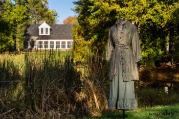 Gabled Duster Coat in Peace and Civility Stripe Linen; Gabled Shirt Jacket in Civility Washed Linen; Gabled Trousers in Civility Washed Stretch Weave; Clotaire Sash in Civility Garden Row Silk Chiffon. Location: Near the bridge and entrance to Stone Cottage and Val-Kill Cottage, the home of Eleanor Roosevelt. Eleanor Roosevelt National Historic Site, Hyde Park, New York.