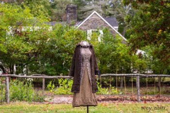 Gabled Duster Coat in Civility Floral Stretch Weave; Gabled Shirt Jacket in Civility Washed Linen; Baedeker Scarf in Dignity Soft Plaid Flannel; Gabled Skirt in Dignity Floral Cotton Twill. Location: Eleanor's garden and west profile of Stone Cottage. Eleanor Roosevelt National Historic Site. Val-Kill, Hyde Park, New York.