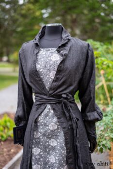 Scattergood Duster Coat in Unity Washed Linen; Scattergood Frock in Unity Floral Linen. Location: Inside Eleanor's rose garden and behind the old forge used to create pewter for Val-Kill Industries. When Val-Kill closed, Eleanor turned the factory into her home and the forge into a playhouse for her grandchildren. Eleanor Roosevelt National Historic Site. Hyde Park, New York.