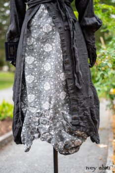 Scattergood Duster Coat in Unity Washed Linen; Scattergood Frock in Unity Floral Linen. Location: Inside Eleanor's rose garden and behind the old forge used to create pewter for Val-Kill Industries. When Val-Kill closed, Eleanor turned the factory into her home and the forge into a playhouse for her grandchildren. Eleanor Roosevelt National Historic Site. Hyde Park, New York.