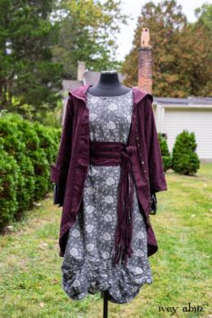 Arthur Hill Duster Coat in Honour Floral Stretch Weave; Porte Cochere Sash in Honour Floral Stretch Weave; Chevaller Cardigan in Unity Soft Ribbed Knit; Scattergood Frock in Unity Floral Linen. Location: Inside Eleanor's rose garden and behind the old forge used to create pewter for Val-Kill Industries, a furnitue and pewter business Eleanor owned and helped operate. When Val-Kill closed, Eleanor turned the factory into her home and the forge into a playhouse for her grandchildren. Eleanor Roosevelt National Historic Site. Hyde Park, New York.