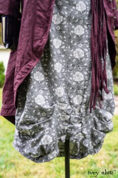 Arthur Hill Duster Coat in Honour Floral Stretch Weave; Porte Cochere Sash in Honour Floral Stretch Weave; Chevaller Cardigan in Unity Soft Ribbed Knit; Scattergood Frock in Unity Floral Linen. Location: Inside Eleanor's rose garden and behind the old forge used to create pewter for Val-Kill Industries, a furnitue and pewter business Eleanor owned and helped operate. When Val-Kill closed, Eleanor turned the factory into her home and the forge into a playhouse for her grandchildren. Eleanor Roosevelt National Historic Site. Hyde Park, New York.