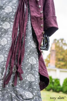 Arthur Hill Duster Coat in Honour Floral Stretch Weave; Porte Cochere Sash in Honour Floral Stretch Weave; Chevaller Cardigan in Unity Soft Ribbed Knit; Scattergood Frock in Unity Floral Linen. Location: Inside Eleanor's rose garden and behind the old forge used to create pewter for Val-Kill Industries, a furnitue and pewter business Eleanor owned and helped operate. When Val-Kill closed, Eleanor turned the factory into her home and the forge into a playhouse for her grandchildren. Eleanor Roosevelt National Historic Site. Hyde Park, New York.