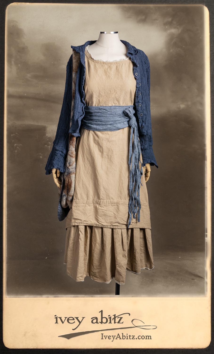 Crest Jacket in Hudson Blue Washed Crinkled Linen; Blanchefleur Frock in Sun and Sand Washed Stripe; Porte Cochere Sash in Estuary Herringbone Weave; Solomon Bag in Carriage Blanket Wool.