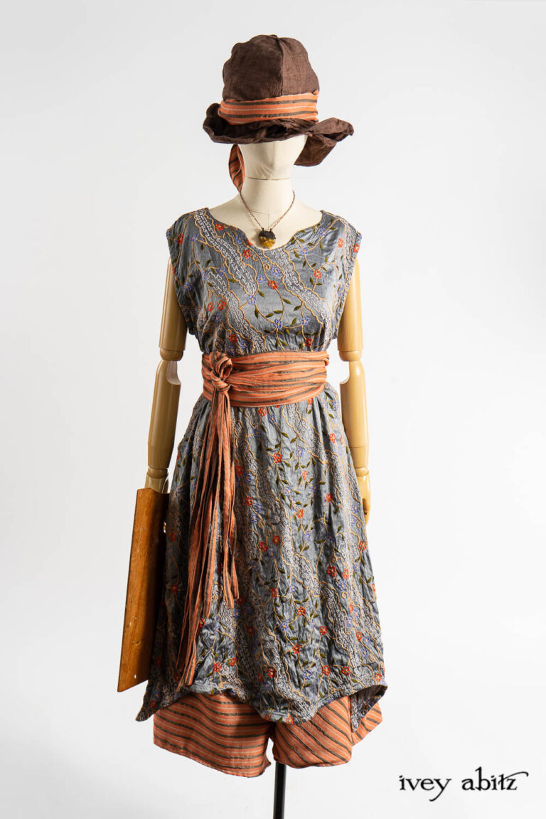 Nook Frock in Raphaelite Embroidered Washed Silk; Porte Cochere Sash in Fauvist Raised Stripe Weave; Cossart Culottes in Fauvist Raised Stripe Weave; Hapgood Hat in Realism Crushed Weave; Fitz Necktie in Fauvist Raised Stripe Weave; Renaissance Necklace.