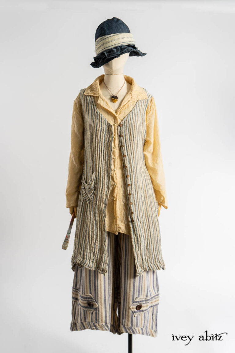Ellis Frock in Academic and Realism Rustic Stripe; Ellis Shirt in Baroque Flocked Floral Voile; Camilla Trousers in Academic Woven Stripe; Hapgood Hat in Academic Finest Everyday Weave; Clotaire Sash in Academic Rustic Stripe; Nouvelle Necklace.