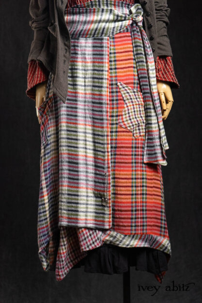 Limited Edition Gilbert Cardigan in Earth and Iron Petite Stripe Knit; Highlands Shirt in Ruby Embroidered Stripe Silk; Nouvelle Necklace; Highlands Skirt in Gem Softest Plaid Wool; Essentielle Frock in Signature Black Washed Silk Jersey Knit. - Bespoke clothing by Ivey Abitz.