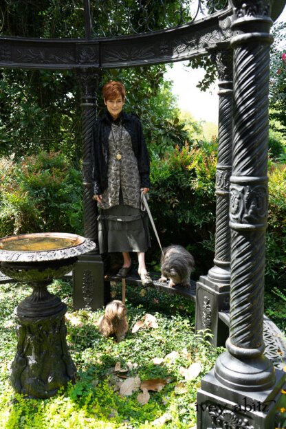 Truitt Shirt Jacket in Black Diamond Floral Voile; Baedeker Scarf (Petite) in Black Diamond Silk Velvet; Hapgood Hat in Black Diamond Crushed Velvet; Nouvelle Necklace; Truitt Frock in Pewter and Stone Floral Linen; Hudson Frock in Olive Quartz Crinkled Weave. - Bespoke clothing by Ivey Abitz. Featuring Carolyn Hennesy with rescue dogs and cats.